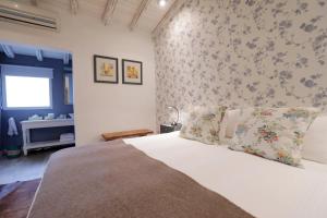 a bedroom with a white bed with floral wallpaper at Finca Adalgisa in Chacras de Coria
