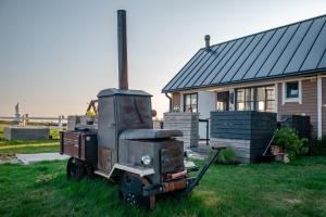 an old truck sitting in the grass in front of a house at Pakri Parun in Paldiski