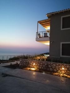 a house with a balcony with a view of the ocean at MELIKIRON LUXURY APARTMENTS in Ayios Nikitas