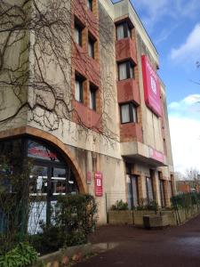 un bâtiment avec un panneau sur son côté dans l'établissement Hipotel Paris Marne La Vallée, à Noisiel