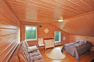una camera da letto in una cabina di legno con letto e scrivania di Ylläs Eeli a Ylläs