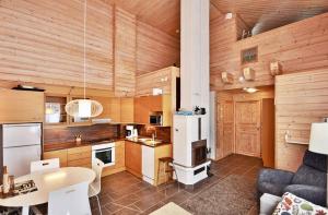 cocina con paredes de madera, mesa y nevera en Ylläs Eeli, en Ylläs