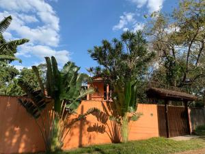 uma casa com cerca e algumas palmeiras em Casa na Praia de Maresias em Maresias