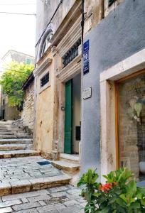 um edifício com uma porta verde numa rua em L&L Rooms Royal em Sibenik