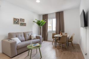 a living room with a couch and a table at Apartamentos Venecia in Lloret de Mar