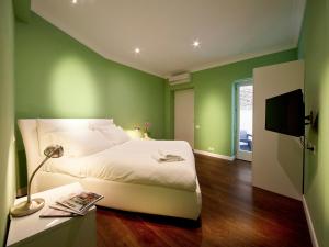 ローマにあるザ ワン プラティ ルームスの緑の壁のベッドルーム(ベッド1台、テーブル付)