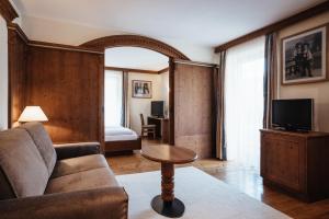 salon z kanapą i stołem w obiekcie Kristallhotel Corona-Krone w mieście San Vigilio di Marebbe