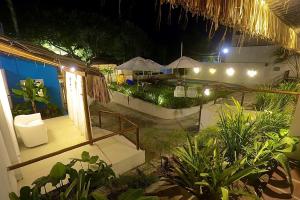 a house with a deck with a pool at night at Pousada Ponta Mar in Natal
