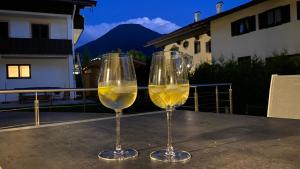two glasses of white wine sitting on a table at Lea am See - Bio Design Appartement in Tegernsee