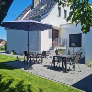 a patio with a table and chairs and an umbrella at Ferienwohnung ,,Zum Posthaus" in Kolkwitz +13 photos