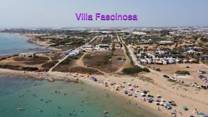 una vista aerea di una spiaggia con persone e ombrelloni di Villa Fascinosa a Portopalo