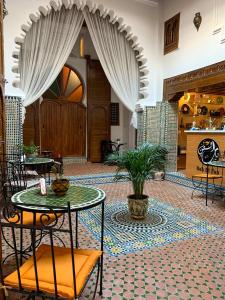 una hall con tavolo e pianta sul pavimento di Riad & Café culturel BAB EL FAN a Tétouan