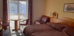 um quarto de hotel com uma cama, uma mesa e uma janela em 2 Zimmer Mitterdorf em Philippsreut