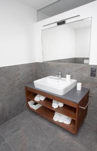 ein Bad mit einem Waschbecken und einem Spiegel in der Unterkunft Apartments Vorhöfe in Morter