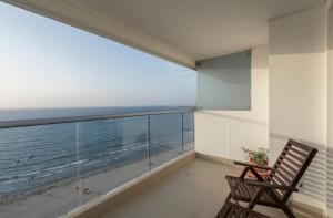 a balcony with a chair and a view of the ocean at Relaxing 1 BR Beachfront Apartment w Wifi and Pool in Cartagena de Indias