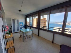 a room with a table and chairs and a view of the water at Apartment Diamond in Benidorm