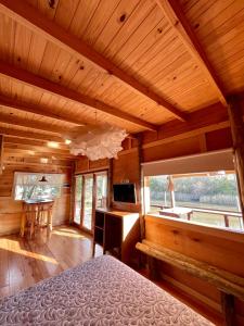 a bedroom in a log cabin with a bed and a desk at Eco Cabaña Río con Pileta privada in Tigre