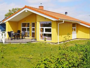 グレーミッツにあるThree-Bedroom Holiday home in Grömitz 18の庭のテーブル付き黄色い家