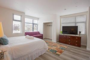 a bedroom with a bed and a flat screen tv at Comfy Studio with Cali King Size Mattress in San Diego