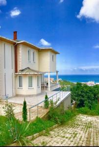 a large white house with the ocean in the background at Sadik Villa (Sea View 4 Bedrooms and 4 Bathrooms) in Trabzon