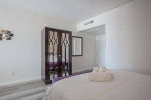 Schlafzimmer mit einem großen weißen Bett und einem Spiegel in der Unterkunft Luxurious Design One Bedroom Apt near Balboa Park in San Diego