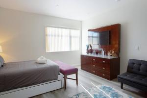 Un dormitorio con una cama, un televisor y una silla. en Luxurious Furnished Studio w Full Kitchen in SD, en San Diego