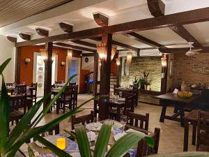 a restaurant with tables and chairs and a brick wall at Pousada Caminho do Sol in Arraial do Cabo