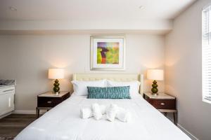 1 dormitorio con 1 cama blanca grande y 2 lámparas en Luxurious Studio in Heart of San Diego w Cali King en San Diego