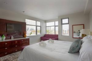 1 dormitorio con 1 cama blanca grande y 1 sofá rojo en Downtown View 4 Sleepers Studio- Great for Getaway, en San Diego