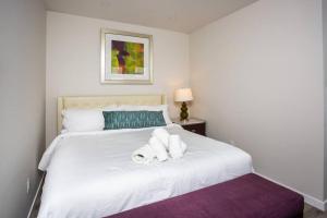 a white bed with two rolled up towels on it at One Bedroom Apartment with Luxurious Furnitures in San Diego