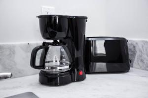 a black coffee maker on a counter next to a microwave at One Bedroom Apartment with SD Downtown View in San Diego