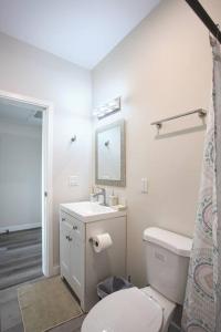 a white bathroom with a toilet and a sink at One Bedroom Apartment with SD Downtown View in San Diego