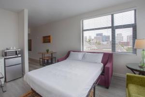 サンディエゴにあるCali King Size One Bedroom Luxurious Suite in DTSDの大きな白いベッドとキッチンのある寝室