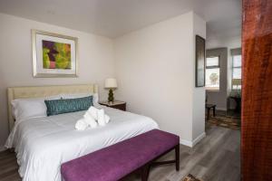 サンディエゴにあるPrime Location - Awesome View -1 bedroom Apartmentのベッドルーム(紫色のベンチ付きの大きな白いベッド付)