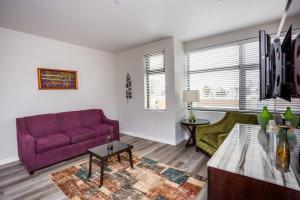 サンディエゴにあるPrime Location - Awesome View -1 bedroom Apartmentの紫色のソファとテーブル付きのリビングルーム