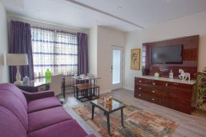 a living room with a purple couch and a tv at Spacious 1 Bedroom Apartment in Heart of San Diego in San Diego
