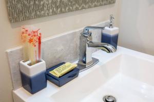 a sink with a faucet and a toothbrush holder at Spacious 1 Bedroom Apartment in Heart of San Diego in San Diego