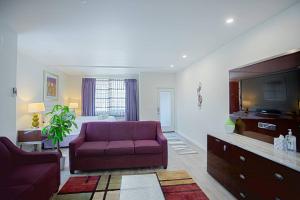 a living room with a purple couch and a tv at Spacious 500 sqft Studio with Balboa Park View in San Diego