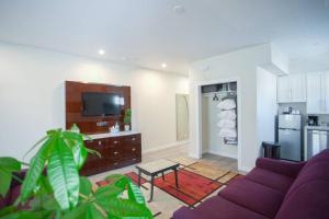 a living room with a purple couch and a kitchen at Spacious 500 sqft Studio with Balboa Park View in San Diego