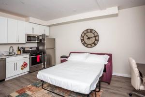 eine Küche mit einem Bett in einem Zimmer mit einer Uhr an der Wand in der Unterkunft 1 Bedroom Apartment with Luxurious Design in SD in San Diego
