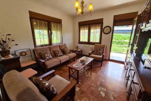 a living room with couches and tables and a clock at 801A Casa de 4 dormitorios en plena naturaleza in Muñás