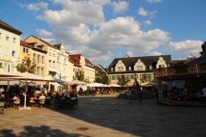 a town square with people sitting at tables and buildings at CASA UNA im Herzen von Bad Kreuznach in Bad Kreuznach