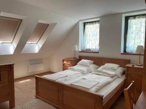 a bedroom with a large bed and two windows at Somló Kolonics Kúria in Somlóvásárhely
