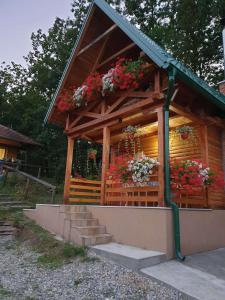 a wooden building with flowers in the window at Brvnare Dunja 1 i Dunja 2 in Kraljevo