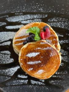 two pancakes with hearts and berries on a black plate at Eco Xata in Santa Verónica