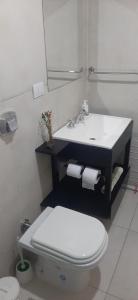 y baño con aseo blanco y lavamanos. en Luminoso departamento de dos ambientes externo en Mar del Plata