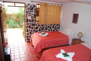 1 dormitorio con 2 camas y toallas. en Kiswar Lodge, en Ollantaytambo