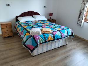 a bedroom with a bed with a colorful comforter at Peace and Tranquility in Ballymote