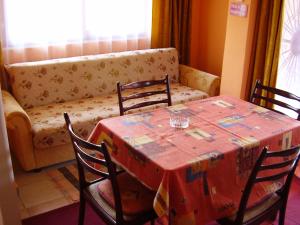 - une salle à manger avec une table, des chaises et un canapé dans l'établissement Andrea apartman, à Zamárdi