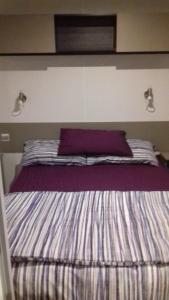 uma cama num quarto com duas luzes na parede em Les Charmettes - SIBLU em Les Mathes